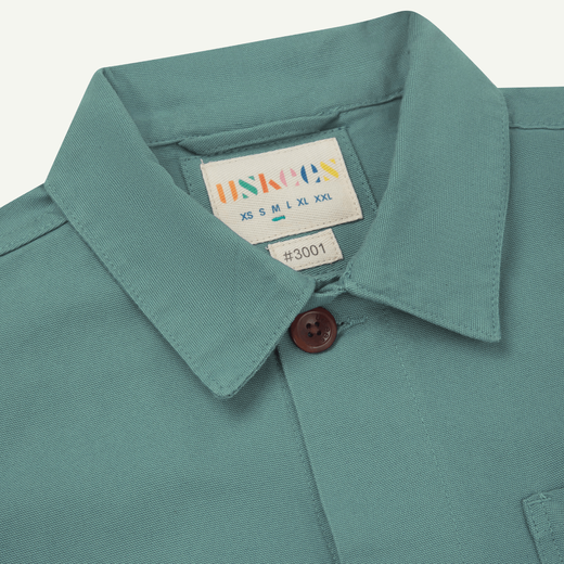 A detail of the nape of a dusty blue overshirt.